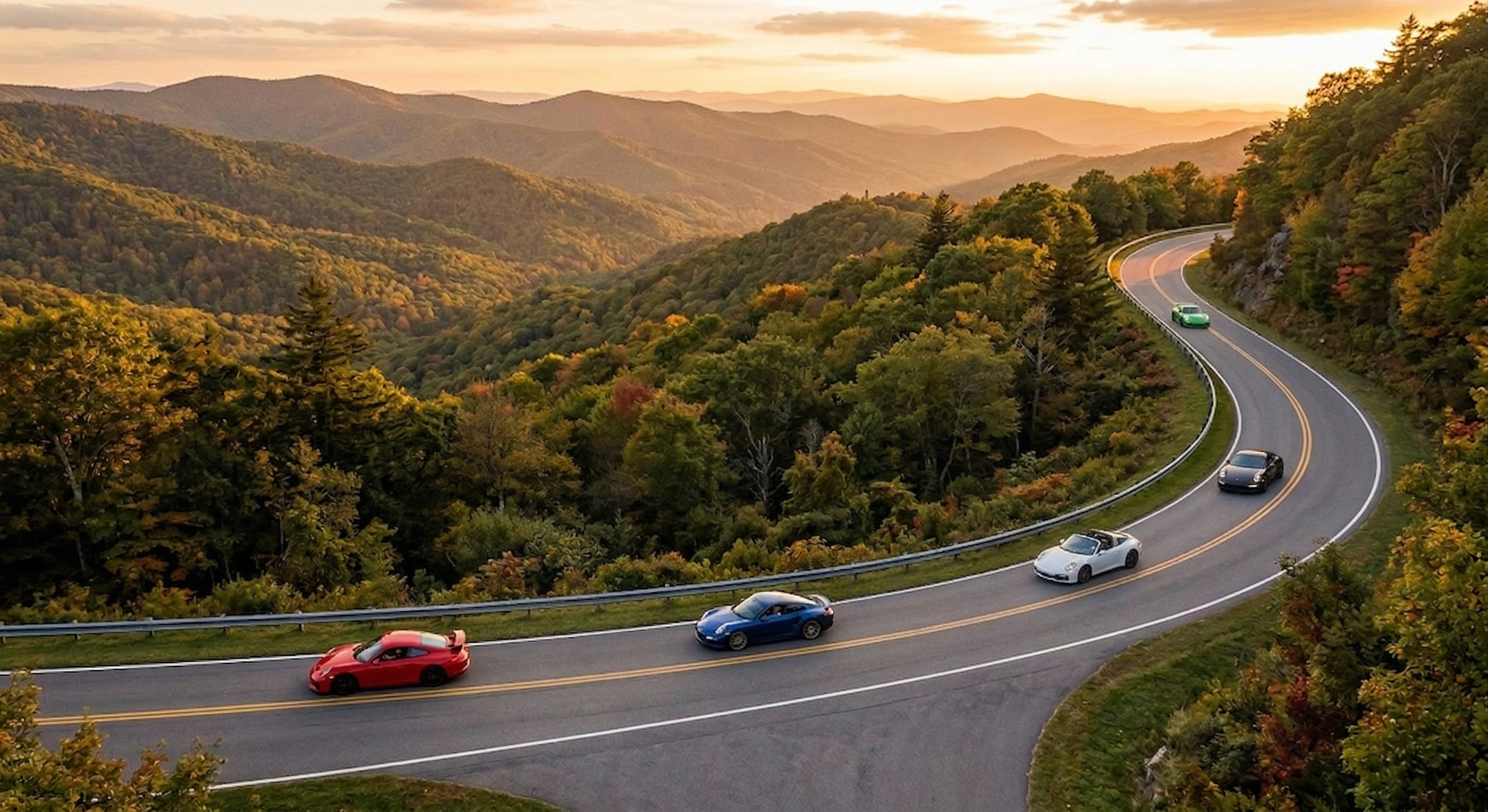 A sports car on an empty ridgeline road at golden hour
